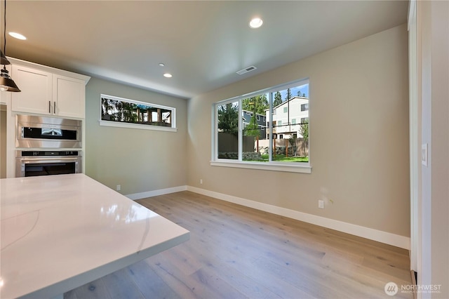 26517 NE 147th Pl Unit Sr 13, Duvall, WA 98019 - kitchen with oven, light wood-type flooring, recessed lighting, white cabinets, and pendant lighting