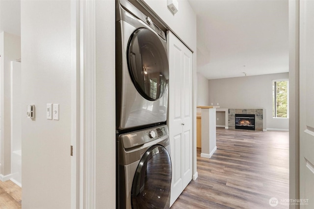 15325 SE 155th Pl Unit N-2, Renton, WA 98058 - laundry room with stacked washer and clothes dryer, light wood-style flooring, and a fireplace