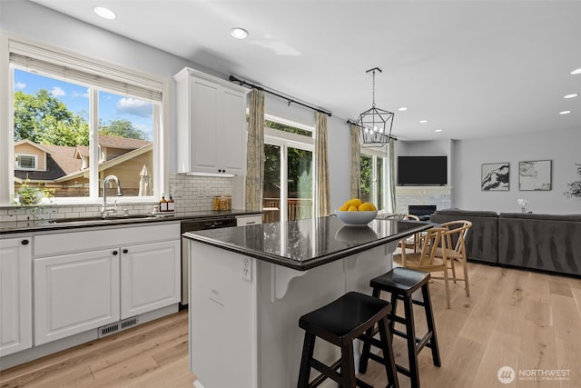 8122 NE 189th Pl, Kenmore, WA 98028 - kitchen with dishwashing machine, white cabinets, recessed lighting, decorative backsplash, and a breakfast bar area
