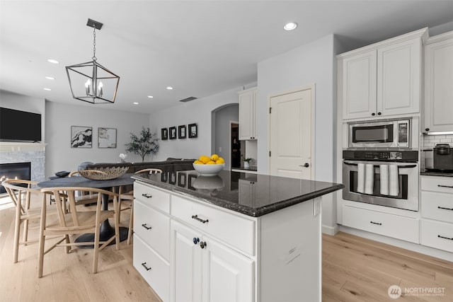 8122 NE 189th Pl, Kenmore, WA 98028 - kitchen featuring appliances with stainless steel finishes, open floor plan, light wood-style floors, a kitchen island, and white cabinets