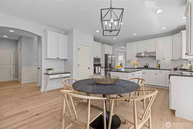 8122 NE 189th Pl, Kenmore, WA 98028 - kitchen featuring stainless steel appliances, dark countertops, arched walkways, light wood-style floors, and recessed lighting