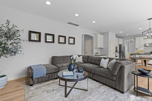 8122 NE 189th Pl, Kenmore, WA 98028 - living room featuring light wood-type flooring, arched walkways, recessed lighting, and a chandelier