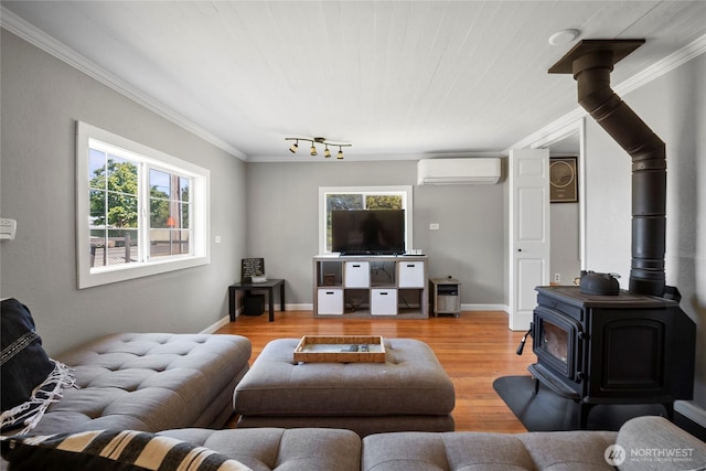 1580 134th Ln, Long Beach, WA 98631 - living area with a wall mounted AC, a wood stove, plenty of natural light, light wood-style floors, and crown molding