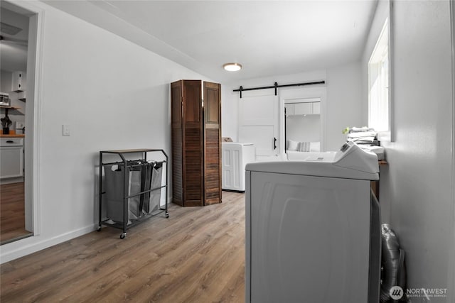 1580 134th Ln, Long Beach, WA 98631 - laundry area with washer / dryer, wood finished floors, a barn door, and cabinet space