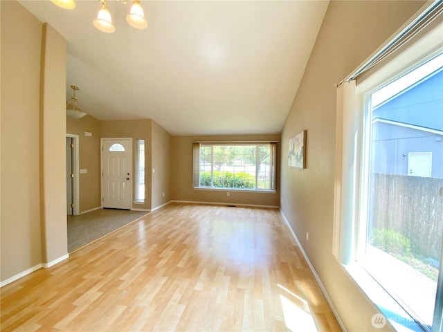 2218 143rd Street Ct S, Spanaway, WA 98387 - unfurnished living room featuring vaulted ceiling, light wood-style flooring, and a chandelier