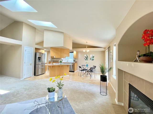 2218 143rd Street Ct S, Spanaway, WA 98387 - living area featuring light carpet, a tile fireplace, high vaulted ceiling, and a skylight