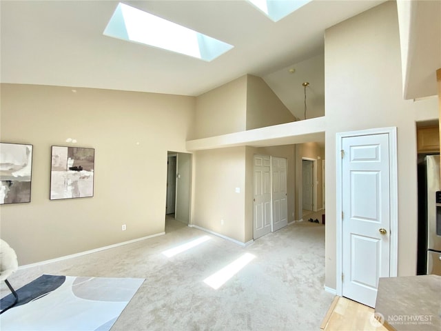 2218 143rd Street Ct S, Spanaway, WA 98387 - unfurnished living room featuring high vaulted ceiling, a skylight, and light carpet