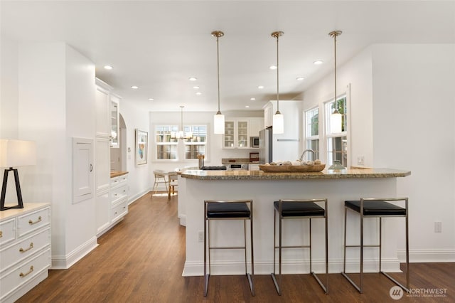 817 E Shelby St, Seattle, WA 98102 - kitchen featuring a peninsula, glass insert cabinets, white cabinets, a breakfast bar, and recessed lighting