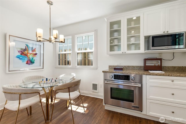 817 E Shelby St, Seattle, WA 98102 - kitchen featuring appliances with stainless steel finishes, a chandelier, white cabinets, dark wood-style floors, and glass insert cabinets