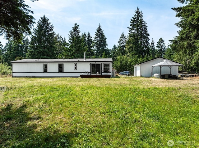 32205 71st Ave S, Roy, WA 98580 - back of property featuring a lawn, an outdoor structure, and view of scattered trees