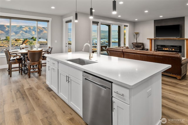 101 Wren Loop SW, Mattawa, WA 99349 - kitchen with stainless steel dishwasher, recessed lighting, light wood-type flooring, a center island with sink, and white cabinetry