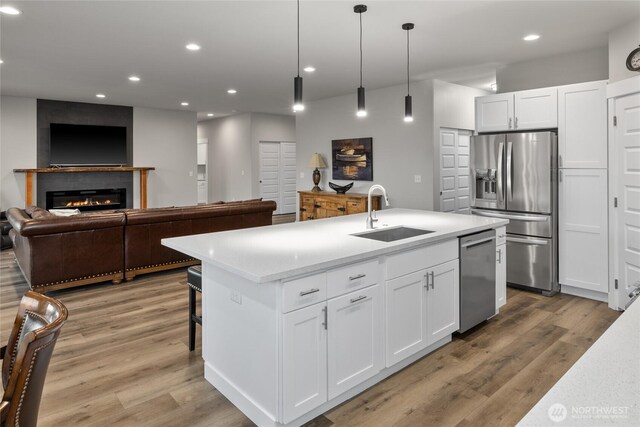 101 Wren Loop SW, Mattawa, WA 99349 - kitchen featuring appliances with stainless steel finishes, open floor plan, light countertops, white cabinetry, and light wood finished floors