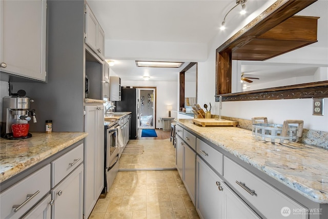 10208 D St E, Tacoma, WA 98445 - kitchen with ceiling fan, light stone counters, and stainless steel range with electric stovetop