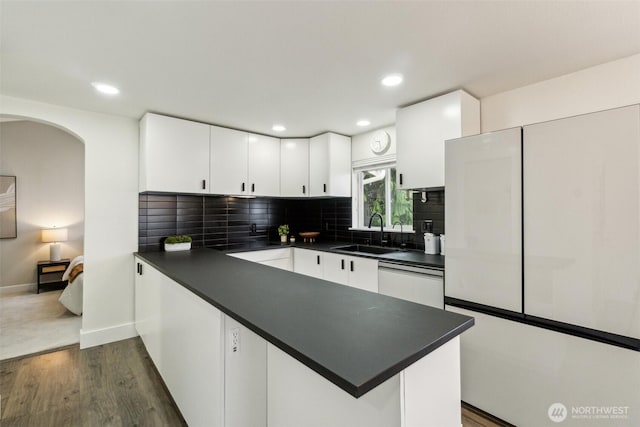 5467 16th Ave SW, Seattle, WA 98106 - kitchen with dark countertops, dishwashing machine, a peninsula, white cabinets, and recessed lighting