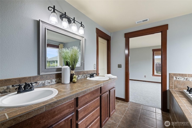15204 Kayla St SE, Yelm, WA 98597 - bathroom with double vanity, plenty of natural light, tile patterned floors, and a relaxing tiled tub