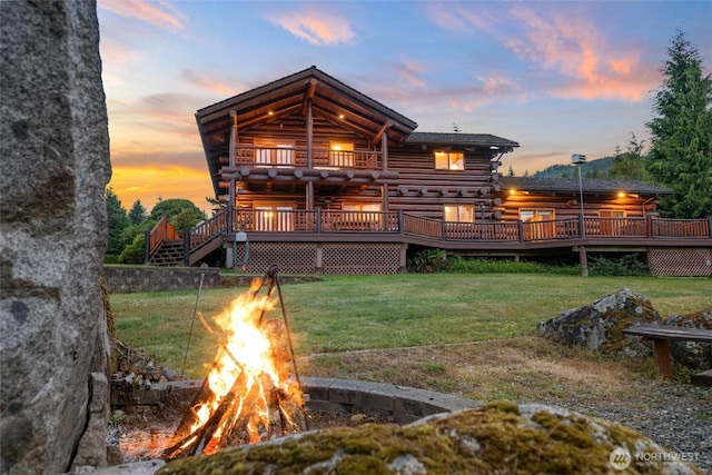 3130 S Bay Vista Dr, Sedro Woolley, WA 98284 - back of house at dusk with a fire pit, log exterior, a deck, and a yard