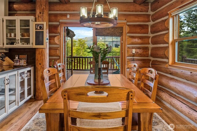 3130 S Bay Vista Dr, Sedro Woolley, WA 98284 - dining room featuring log walls, plenty of natural light, light wood finished floors, beam ceiling, and a chandelier