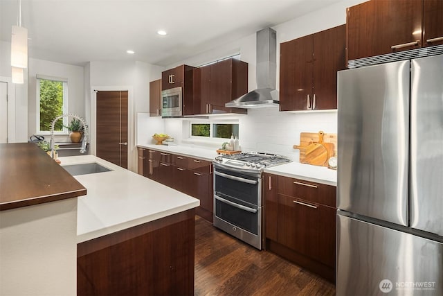 1408 Hinoki Walk NE, Issaquah, WA 98029 - kitchen featuring appliances with stainless steel finishes, wall chimney exhaust hood, decorative backsplash, dark wood-style floors, and recessed lighting