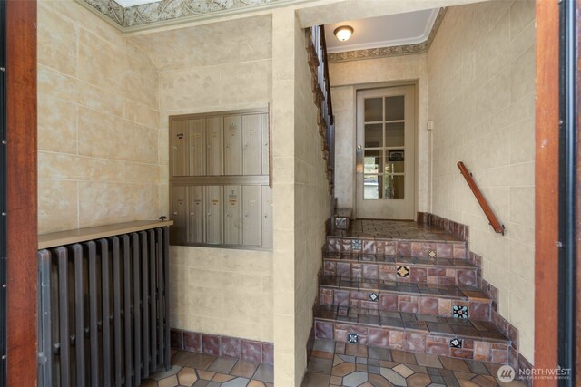 405 Prospect St Unit 201, Seattle, WA 98109 - staircase featuring tile walls, radiator heating unit, mail area, and ornamental molding