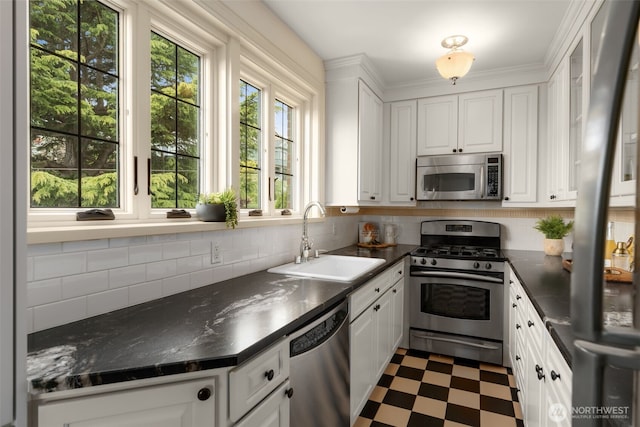 405 Prospect St Unit 201, Seattle, WA 98109 - kitchen featuring appliances with stainless steel finishes, dark floors, dark countertops, and white cabinets