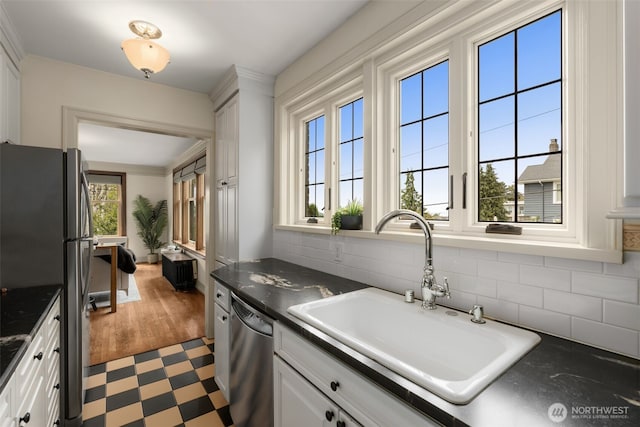 405 Prospect St Unit 201, Seattle, WA 98109 - kitchen featuring appliances with stainless steel finishes, dark countertops, white cabinetry, and tasteful backsplash