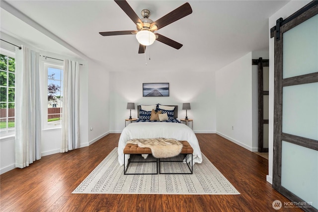 608 14th St SW, Puyallup, WA 98371 - bedroom featuring a barn door, wood finished floors, and a ceiling fan