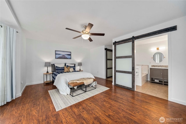 608 14th St SW, Puyallup, WA 98371 - bedroom featuring a barn door, wood finished floors, ensuite bath, and a ceiling fan