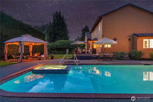 608 14th St SW, Puyallup, WA 98371 - pool at night featuring an in-ground hot tub, an outdoor pool, and a gazebo