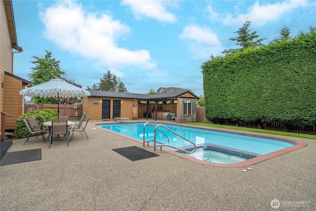 608 14th St SW, Puyallup, WA 98371 - view of pool with an in-ground hot tub, a patio area, an outdoor structure, a storage structure, and outdoor dining space