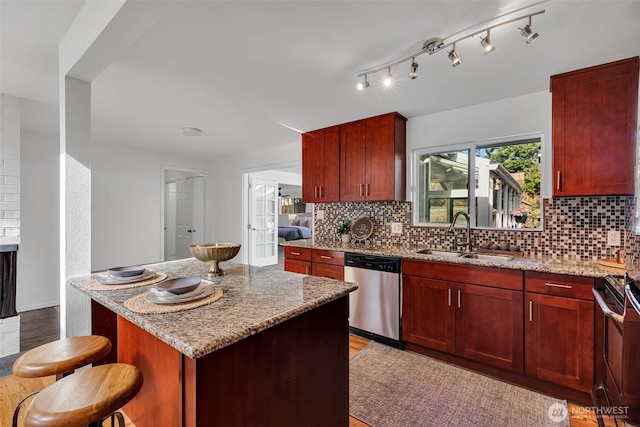 18256 45th Ave S, Seatac, WA 98188 - kitchen with dishwasher, reddish brown cabinets, light stone countertops, and backsplash