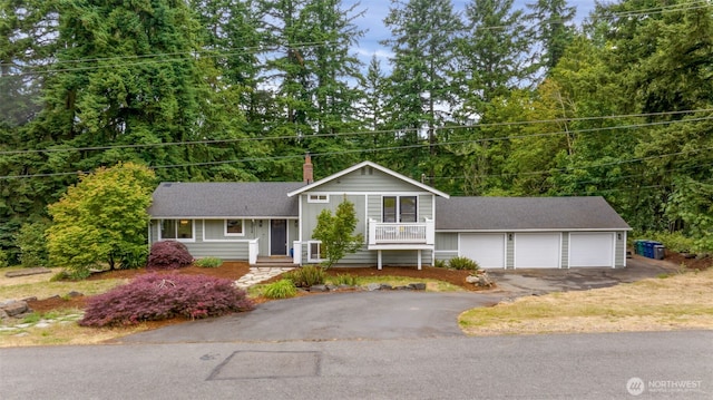 10656 SE 287th St, Auburn, WA 98092 - tri-level home with asphalt driveway, a chimney, a shingled roof, and covered porch