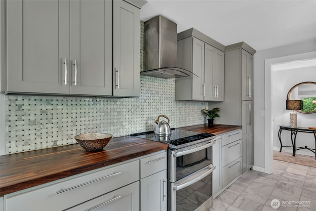 10656 SE 287th St, Auburn, WA 98092 - kitchen with butcher block countertops, wall chimney range hood, double oven range, gray cabinetry, and decorative backsplash