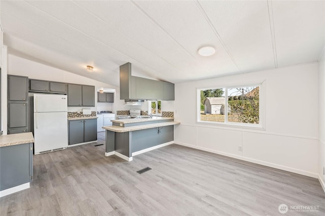 138 Trestle View Ln, Dryden, WA 98821 - kitchen with freestanding refrigerator, gray cabinetry, light countertops, a peninsula, and light wood-style floors