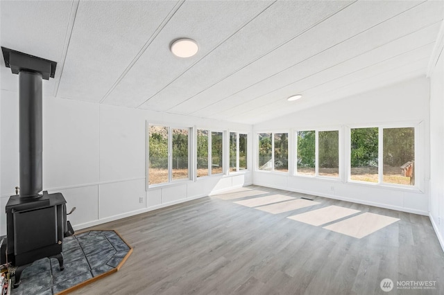 138 Trestle View Ln, Dryden, WA 98821 - unfurnished sunroom with a wood stove, healthy amount of natural light, vaulted ceiling, and wood finished floors