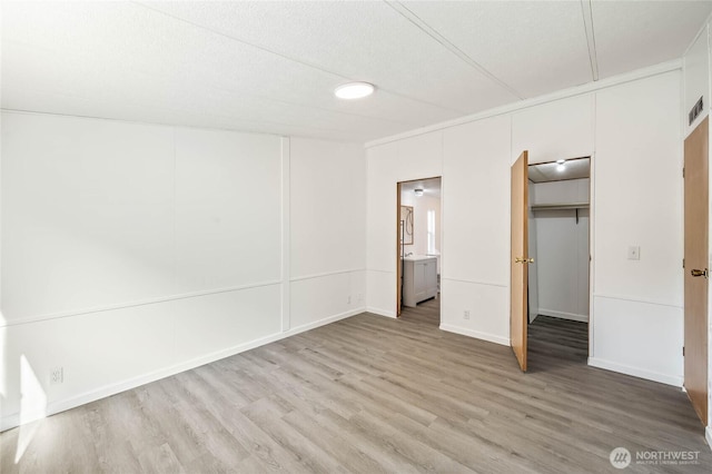 138 Trestle View Ln, Dryden, WA 98821 - unfurnished bedroom with light wood finished floors, a closet, ensuite bath, and a walk in closet