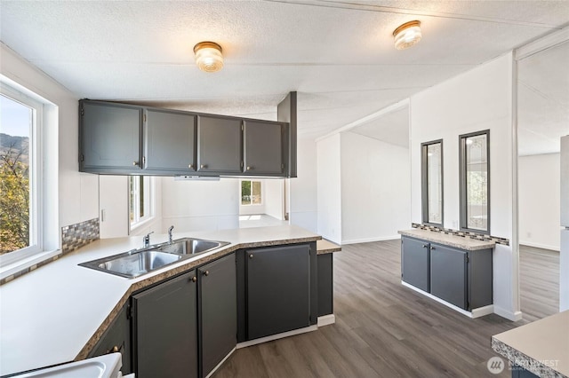 138 Trestle View Ln, Dryden, WA 98821 - kitchen with dark wood-style flooring, gray cabinetry, light countertops, a peninsula, and a textured ceiling