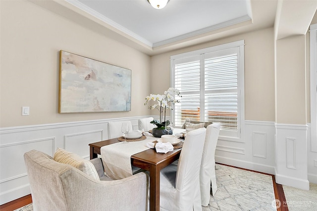 9225 225th Ave E, Buckley, WA 98321 - dining room featuring ornamental molding, wainscoting, wood finished floors, a raised ceiling, and a decorative wall