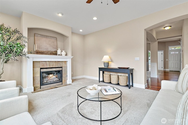 9225 225th Ave E, Buckley, WA 98321 - carpeted living room with a tile fireplace, ceiling fan, arched walkways, and recessed lighting