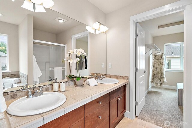 9225 225th Ave E, Buckley, WA 98321 - full bathroom with double vanity, a shower stall, healthy amount of natural light, and tile patterned flooring