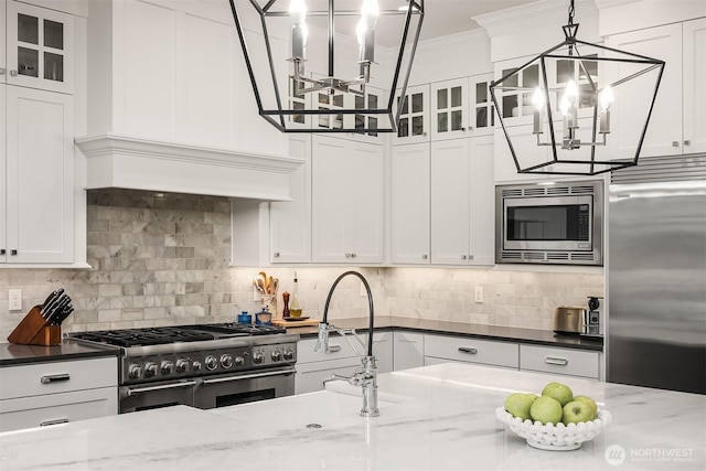 11050 SE 30th St, Bellevue, WA 98004 - kitchen with premium appliances, a chandelier, ornamental molding, white cabinets, and glass insert cabinets