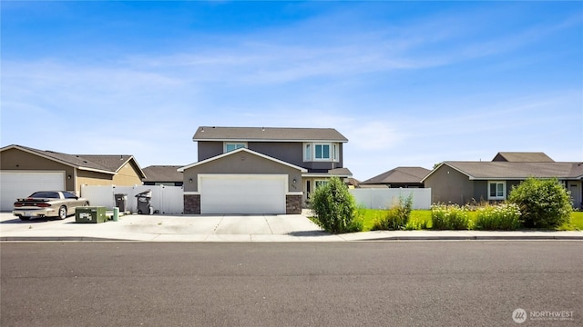 920 E Mt Adams St, Othello, WA 99344 - traditional-style house featuring concrete driveway, stone siding, a garage, a residential view, and stucco siding