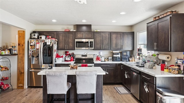 920 E Mt Adams St, Othello, WA 99344 - kitchen featuring stainless steel appliances, dark brown cabinetry, light wood-type flooring, a center island, and recessed lighting
