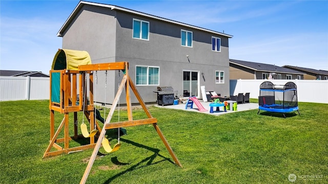 920 E Mt Adams St, Othello, WA 99344 - back of house with a patio area, a playground, a fenced backyard, a trampoline, and stucco siding