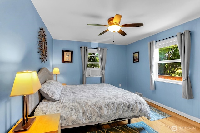11729 Phinney Ave N, Seattle, WA 98133 - bedroom featuring multiple windows, wood finished floors, and ceiling fan