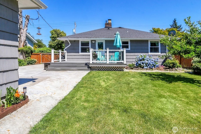 11729 Phinney Ave N, Seattle, WA 98133 - back of house featuring a chimney, roof with shingles, a patio area, and a wooden deck