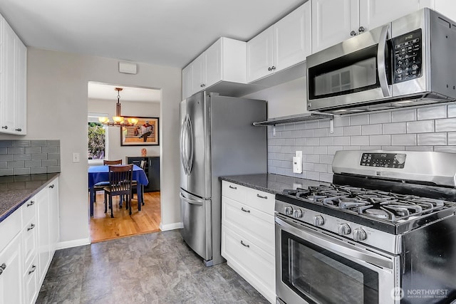 11729 Phinney Ave N, Seattle, WA 98133 - kitchen featuring stainless steel appliances, a chandelier, white cabinets, and dark stone countertops