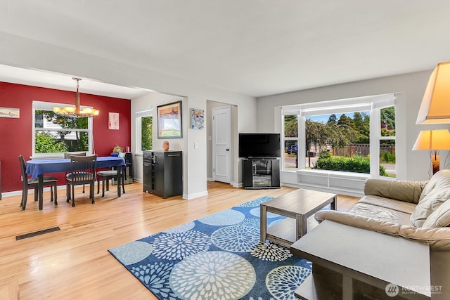 11729 Phinney Ave N, Seattle, WA 98133 - living area featuring a chandelier, light wood-style floors, and plenty of natural light