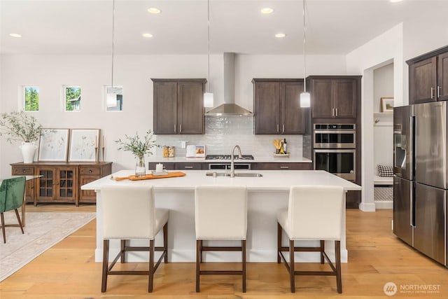 11306 143rd Dr NE, Lake Stevens, WA 98258 - kitchen with stainless steel appliances, wall chimney exhaust hood, a breakfast bar area, dark brown cabinetry, and recessed lighting