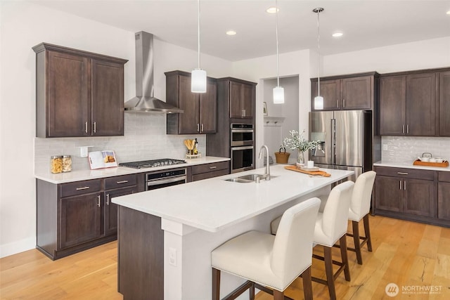 11306 143rd Dr NE, Lake Stevens, WA 98258 - kitchen featuring wall chimney exhaust hood, appliances with stainless steel finishes, a breakfast bar area, decorative backsplash, and dark brown cabinetry