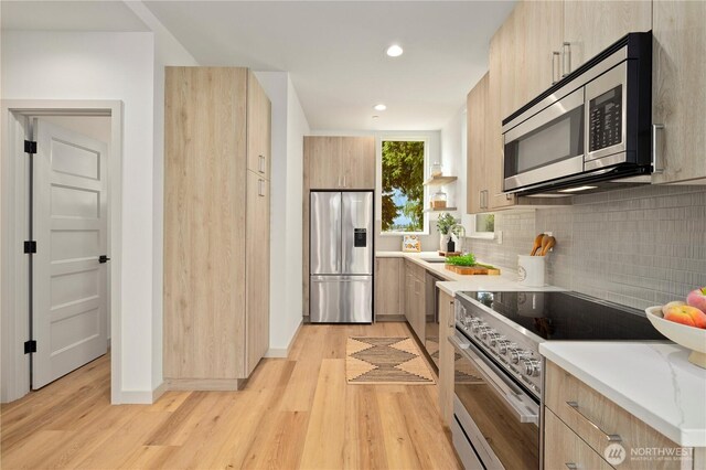 7013 9th Ave NE, Seattle, WA 98115 - kitchen with appliances with stainless steel finishes, modern cabinets, light brown cabinets, tasteful backsplash, and light wood finished floors